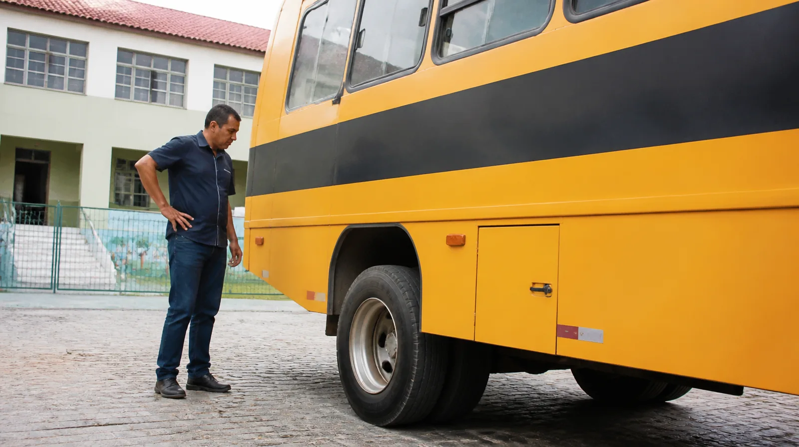 Pneu de veículo escolar em asfalto, destacando segurança e desempenho no transporte de alunos