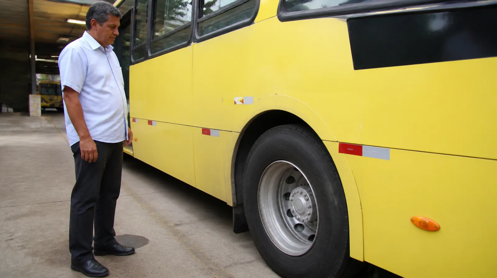Ônibus urbano fotorrealista com pneu em destaque, rodando em via asfaltada e movimento realista